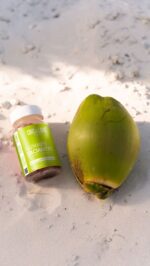 a green coconut with a green label next to a bottle of gummies